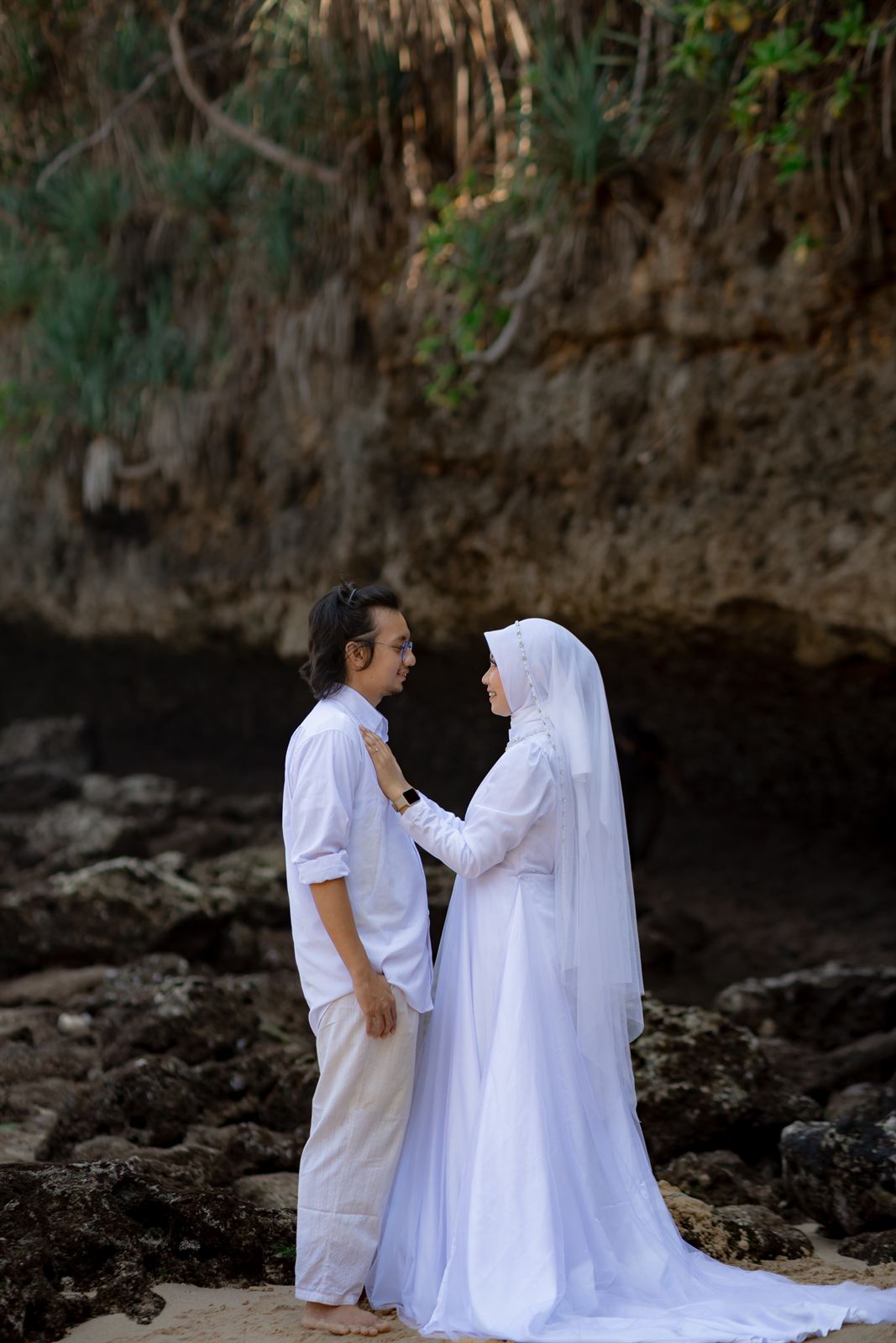 Shovian dan Tita berdiri di depan tebing karang