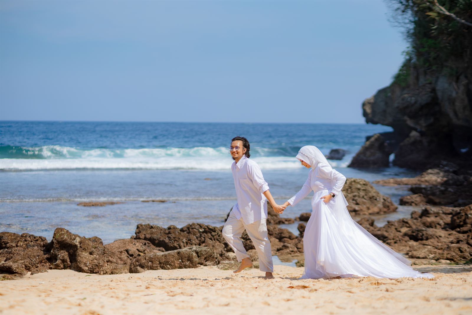 Shovian dan Tita berjalan bergandengan di tepi pantai